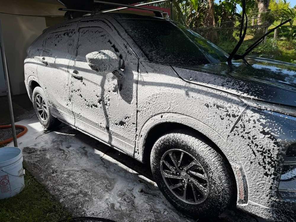SUV cubierta en espuma de pre-lavado bajo toldo